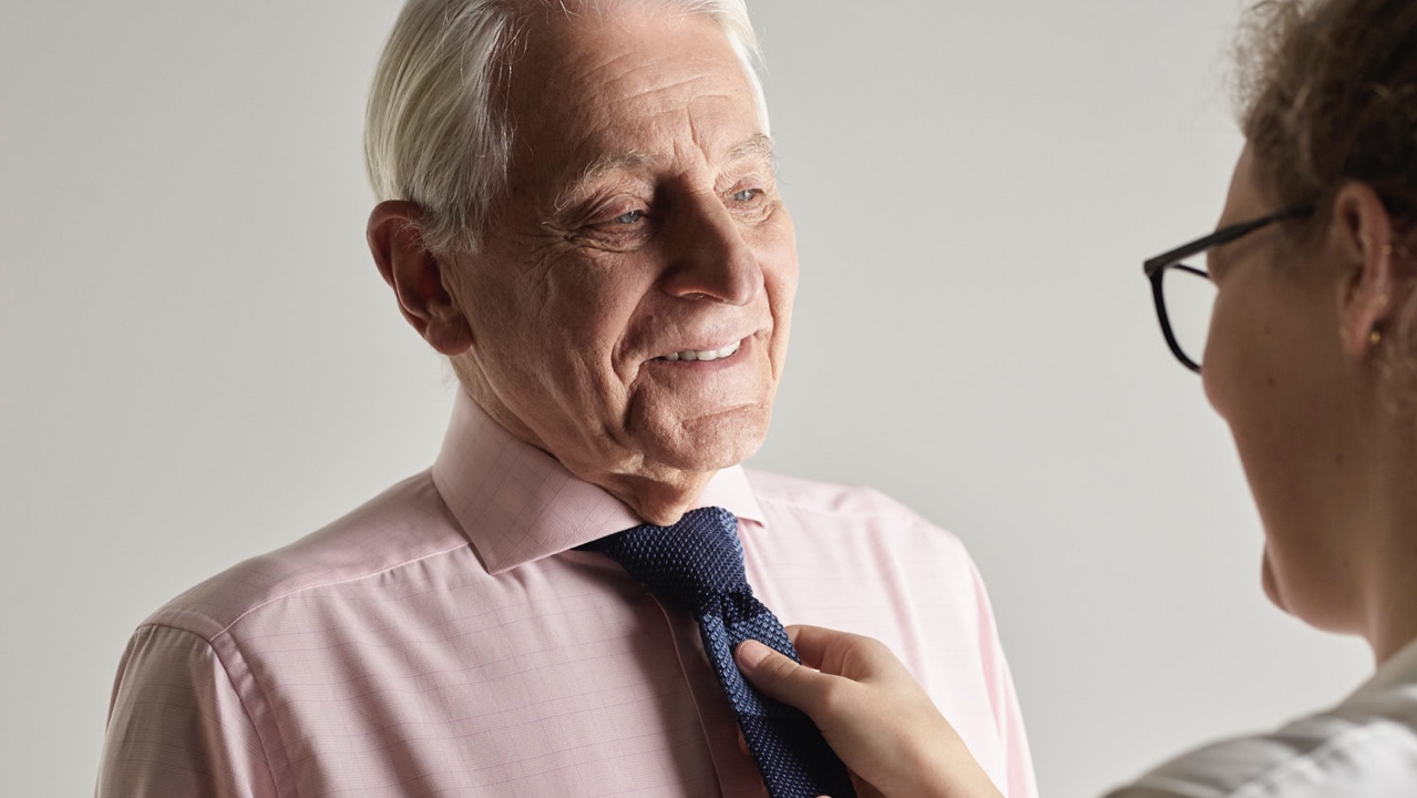Support assistant tying the tie of an elderly gentleman at Morgan Glen Iris